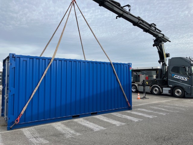 Container de stockage manutentionné par un camion équipé d’une grue